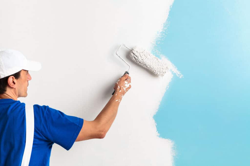 Professional painter repainting an interior wall white