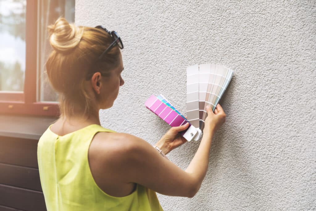 Female homeowner choosing an exterior paint color for her home